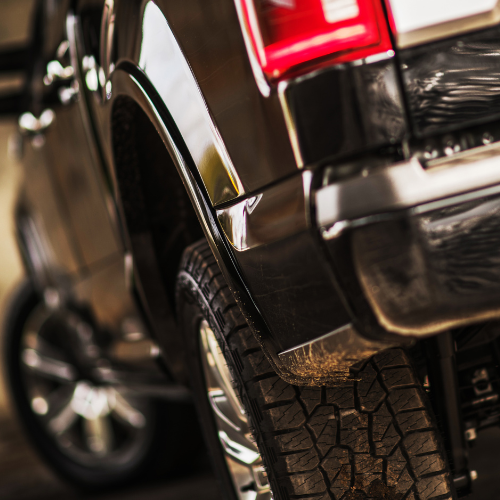 The back end of a black pickup truck.